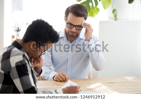 Male job candidate sweating wiping using napkin feel worried at interview with African American millennial employer, man nervous recruiting in office, black HR female manager consider resume