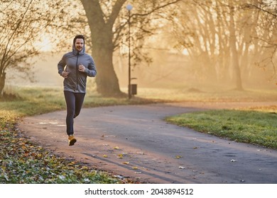 Male jogger in the park on sunny autumn morning