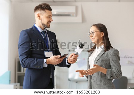 Male journalist having interview with woman indoors