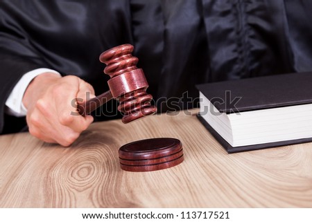 Male Judge In A Courtroom Striking The Gavel
