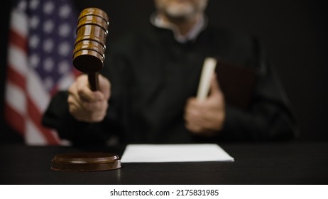 Male judge hitting gavel, calling court members to stand, United States justice system