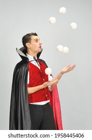 A Male Juggler In A Dracula Costume Juggles Balls. Juggler's Day 