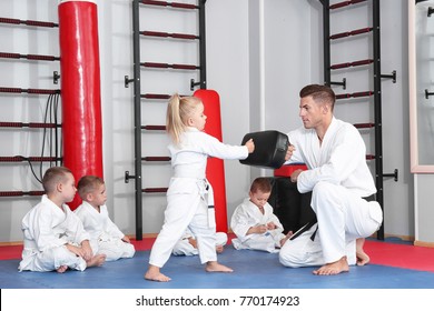 Male karate instructor training little children in dojo - Powered by Shutterstock