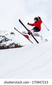 Male Kid Performs A High Jump With The Ski. Winter Season, Red Jacket. Valle D'Aosta, Italy, Europe.