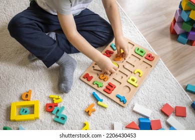 Male Kid Playing With Wooden Eco Friendly Alphabet Letters Board On Table Top View. Intellectual Game Preschool Primary Education Early Development Font Characters For Learning Reading And Writing