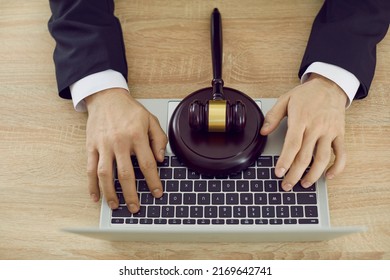 Male Lawyer Or Attorney Sitting At Desk With Laptop And Gavel, Providing Online Law Consultation On Website, Sharing Information, Giving Expert Legal Advice. Crop Shot From Above Hands On Notebook PC