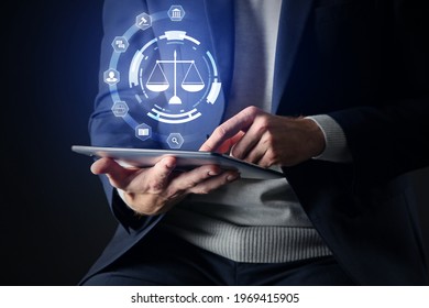 Male Lawyer With Tablet Computer Using Virtual Screen On Dark Background