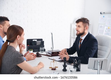 Male lawyer working with clients in office