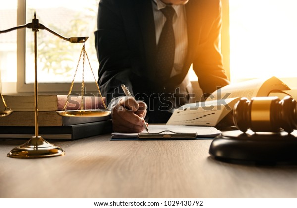 Male lawyer working with contract papers and\
wooden gavel on tabel in courtroom. justice and law ,attorney,\
court judge, concept.