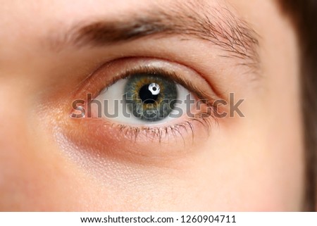Male left green grey coloured eye extreme closeup. Oculist and perfect vision contact lens concept