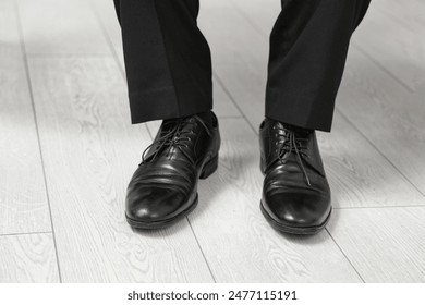 Male legs in stylish leather shoes indoors, closeup - Powered by Shutterstock