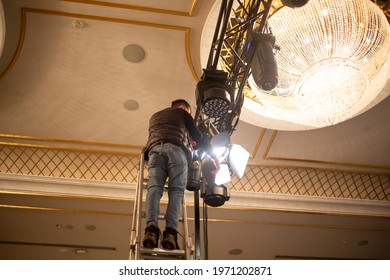 Male Light Technician Is Arranging Fixing Stage Lights On Truss For Show Rehearsal. Stage Light System Set Up.