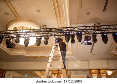 Male Light Technician Is Arranging Fixing Stage Lights On Truss For Show Rehearsal. Stage Light System Set Up.