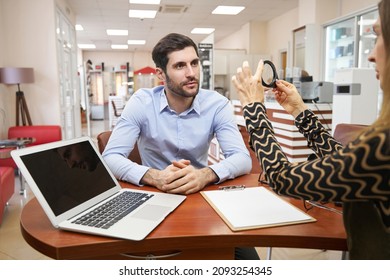 Male listening attentively to optical shop manager with magnifying glass - Powered by Shutterstock