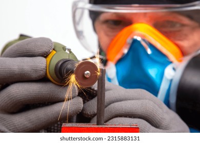 Male locksmith worker processes metal with engraving drill cutting. The work of the dremel engraving electric tool. Industrial metal processing industry - Powered by Shutterstock