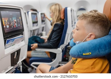 Male, Maldives - July 2021: Teenage Boy Passenger Generation Z On The Plane Sit And Watching Movie In Protective Face Mask, Summer Holidays, Public Transport