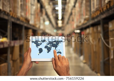 male manager hand holding tablet with AR application for check order pick time in smart factory warehouse, technology interface global partner connection for Logistic Import Export background