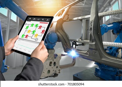 Male manager hand use tablet for check real time vibration analysis monitoring system application in smart factory. Automobile manufacturing production machine , robot arm. industry 4.0 concept.