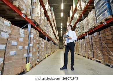 Male Manager Man Standing In Big Modern Warehouse With Tablet Computer