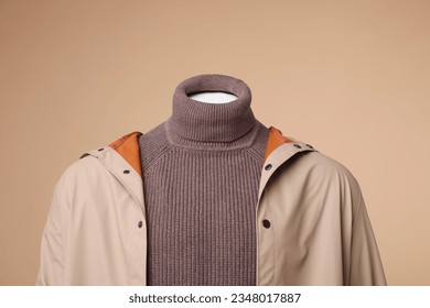 Male mannequin dressed in stylish coat and turtleneck on beige background - Shutterstock ID 2348017887