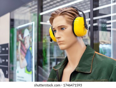 Male mannequin in work clothes with yellow anti-noise headphones on his head.