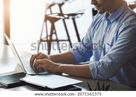 A male marketing manager using a computer to design a company's sales plan to present work to potential venture capitalists to maximize profits.