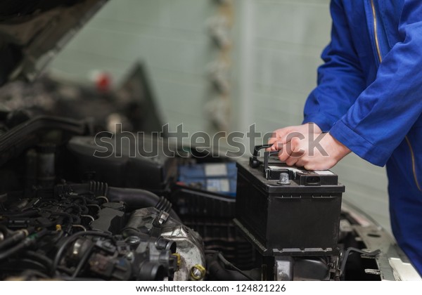 Male mechanic changing car
battery