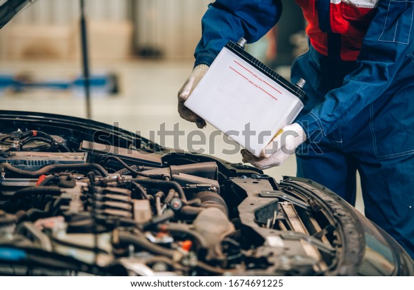 Male mechanic changing car battery, engineer\
is replacing car battery because car battery is depleted. concept\
car maintenance