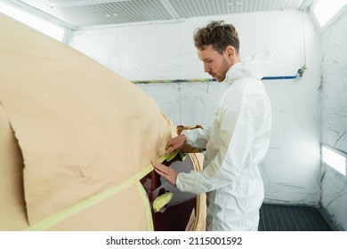 Male mechanic covering body car with paper and masking tape before painting in auto repair service - Powered by Shutterstock