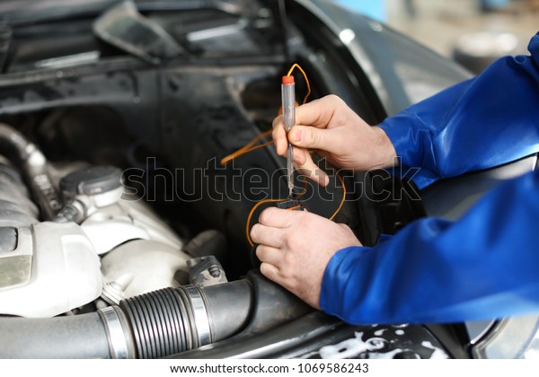 Male mechanic\
examining car in service\
center