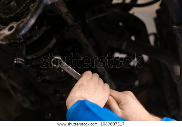 Male mechanic\
fixing car in service\
center