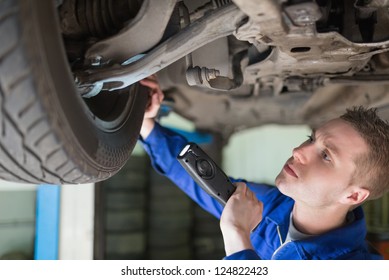 Male mechanic with flashlight examining tire - Powered by Shutterstock