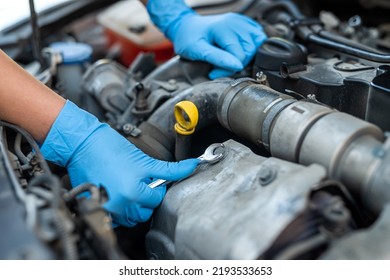 Male Mechanic Help Woman Solve The Problem Of Car Breakdown. He Lifts The Hood Of The Car To Repair The Damaged Part. Man's Hands Close Up