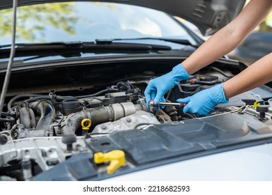 Male Mechanic Help Woman Solve The Problem Of Car Breakdown. He Lifts The Hood Of The Car To Repair The Damaged Part. Man's Hands Close Up