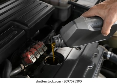 Male Mechanic Pouring Motor Oil From Canister Into Car Engine