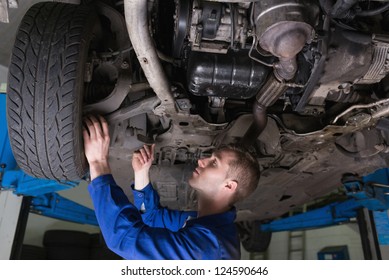 Male Mechanic Under Car In Garage