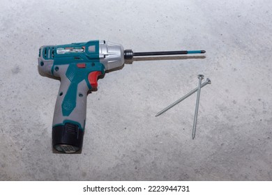 Male Mechanic Using A Cordless Screwdriver Drill With Wood Screws