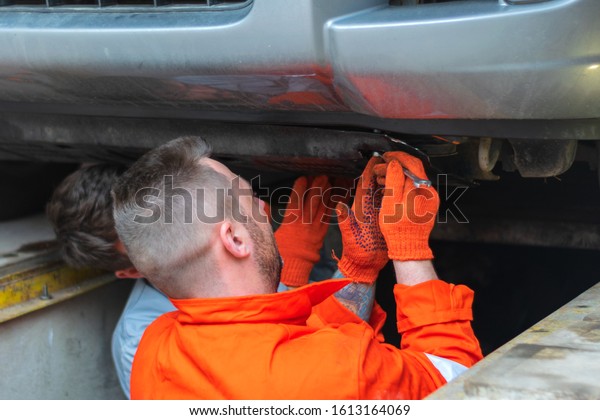 Male mechanics at the\
garage fixing a car. service and maintenance. car repair. fix a\
car. Hot bearded men