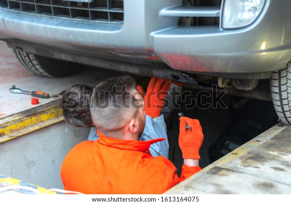Male mechanics at the\
garage fixing a car. service and maintenance. car repair. fix a\
car. Hot bearded men