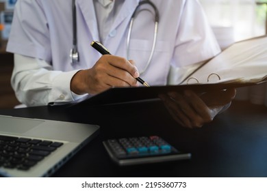 Male Medicine Doctor Hand Holding Pen Writing Something On Clipboard Close Up. Ward Round, Patient Visit Check, Medical Calculation And Statistics Concept.