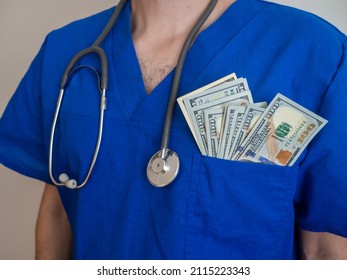 Male Medicine Doctor Holding Money Dollars Banknotes In Pocket. Payment Salary For The Doctor And Nurses Work. Payment To Employees In The Red Zone. Award To Doctors Working With Covid Patients