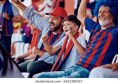 Male members of extended family cheering for their sports team while watching a game from stadium stands.   - Powered by Shutterstock