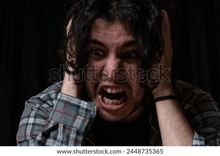 Male model going crazy with anger. Expression of anger. Hands on the model's head. to be angry alone. Body language.