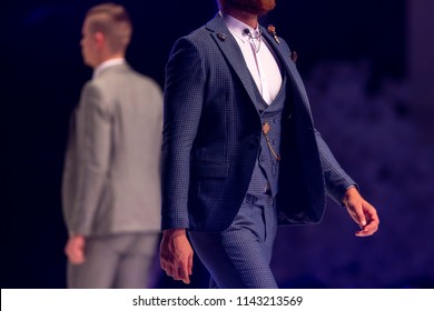 Male Models Walk The Runway In Different Suits During A Fashion Show. Fashion Catwalk Event Showing New Collection Of Clothes.