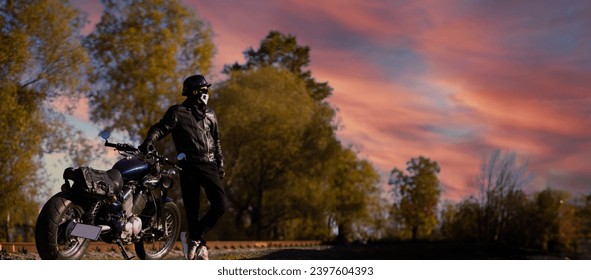 male motorcyclist in a leather jacket and helmet on a vintage custom motorcycle in nature. Concept of motorcycle life and the beginning of the season - Powered by Shutterstock