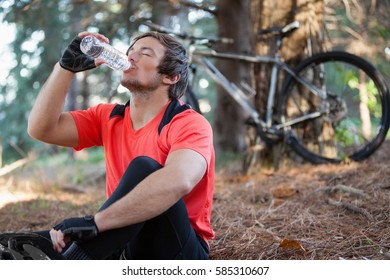 Male Mountain Biker Drinking Water In The Forest