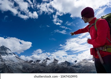 Male Mountain Guide In Red Pointing To Mountain Peak Panorama In The Andes In Peru