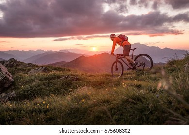 Männliche Mountainbiker bei Sonnenuntergang in den Bergen