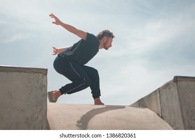 Male Movement Artist Dancing In An Empty Skatepark, Casting A Shadow Into The Skate Pool, From Where The Photo Is Shot.