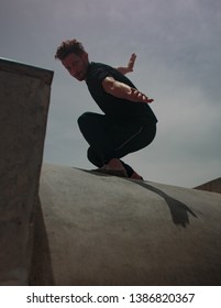 Male Movement Artist Dancing In An Empty Skatepark, Casting A Shadow Into The Skate Pool, From Where The Photo Is Shot.